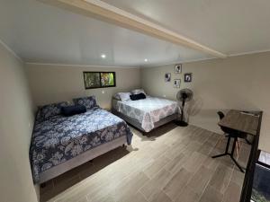 a bedroom with two beds and a desk and a piano at Nani House in Montezuma