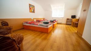 a bedroom with a bed and a wooden floor at Chata Motocentrum in Snina