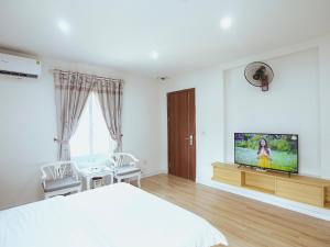 a bedroom with a bed and a flat screen tv at Khách sạn Phúc Thành in Hanoi