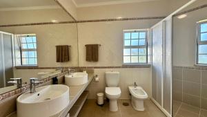 ein Badezimmer mit zwei Waschbecken, einer Toilette und einem Spiegel in der Unterkunft Abby - Private Pool - 11 Guests - Albufeira in Albufeira