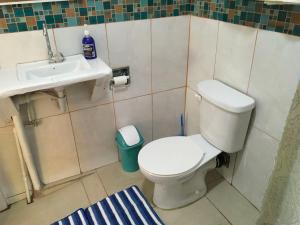 a bathroom with a toilet and a sink at Creole Cottage in Calibishie +17 photos