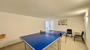 ein blauer Tischtennistisch in einem Raum mit zwei Stühlen in der Unterkunft Abby - Private Pool - 11 Guests - Albufeira in Albufeira