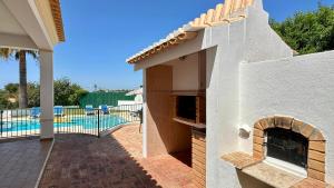 ein Haus mit Kamin neben einem Swimmingpool in der Unterkunft Abby - Private Pool - 11 Guests - Albufeira in Albufeira