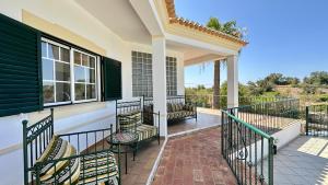 eine Veranda eines Hauses mit Stühlen darauf in der Unterkunft Abby - Private Pool - 11 Guests - Albufeira in Albufeira + 35 Fotos