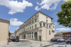 a large white building on a street with parked cars at Best Western Grand Hotel de Castres in Castres