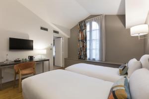 a hotel room with two beds and a desk at Best Western Grand Hotel de Castres in Castres