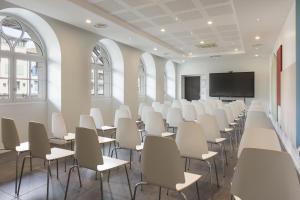 an empty room with white chairs and a projection screen at Best Western Grand Hotel de Castres in Castres