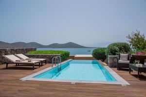 a swimming pool on a deck with a view of the water at Villa Andrea in Elounda