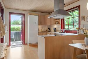 a kitchen with wooden cabinets and a large window at LF12118-Vinderup-Vigen-18 in Handbjerg