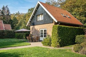 a house with a table and chairs and an umbrella at De Bron | 1-8 pers. in Losser