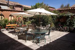 two tables and chairs under an umbrella on a patio at Fuente de Agua in Cusco