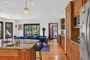 a kitchen with wooden cabinets and blue chairs at Sunny Grove Retreat in Sebastopol