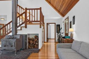 a living room with a fireplace and a staircase at Sunny Grove Retreat in Sebastopol