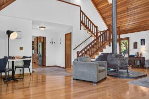 a living room with a staircase and a chair and a table at Sunny Grove Retreat in Sebastopol +40 photos