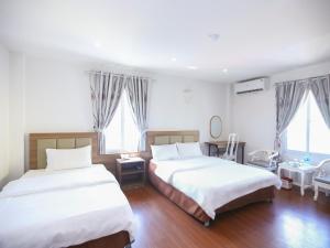 a bedroom with two beds and two windows at Khách sạn Phúc Thành in Hanoi +4 photos