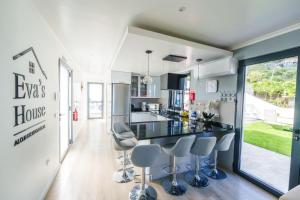 a kitchen with a counter and stools in it at Eva's house in São Vicente
