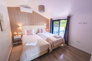 a bedroom with two beds and a large window at Eva's house in São Vicente