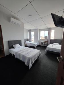 a hotel room with two beds and a flat screen tv at Javaz Hospedaje in Tarapoto +18 photos