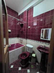 a bathroom with a toilet and a sink and a tub at Javaz Hospedaje in Tarapoto