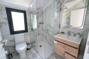 a bathroom with a shower and a toilet and a sink at Eva's house in São Vicente +18 photos