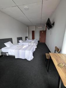 a row of beds in a room with a table at Javaz Hospedaje in Tarapoto