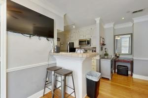 a kitchen with white cabinets and a bar with two stools at Polk 401 in Nashville
