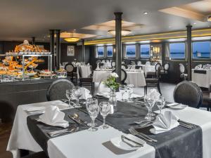 a dining room with white tables and chairs at Mövenpick MS Sunray in Luxor