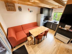a living room with a table and a couch and a kitchen at Chëczka - 2min do Jeziora in Zbychowo +18 photos