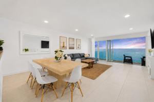 a white living room with a table and a couch at Malibu Beachfront Home with Rock Spa Ocean Views & Huge Deck in Malibu