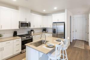 a kitchen with white cabinets and a stainless steel refrigerator at Heated Pool & Pickleball - Spacious & Immaculate Home in Washington