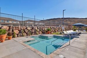 a swimming pool with chairs and an umbrella at Heated Pool & Pickleball - Spacious & Immaculate Home in Washington