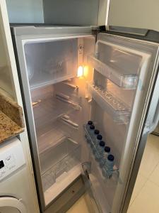 an empty refrigerator with its door open in a kitchen at صلالة مرباط in Mirbāţ