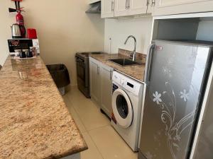 a kitchen with a refrigerator and a washing machine at صلالة مرباط in Mirbāţ +18 photos