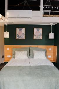 a bedroom with a large bed with a green wall at DOMEGLAMPING at FISHINGLAKE in Ságvár