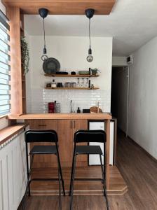 a kitchen with two bar stools at a kitchen counter at Cozy 5 in Belgrade