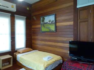 a bedroom with a bed and a flat screen tv at Ban Boonchu in Phra Nakhon Si Ayutthaya