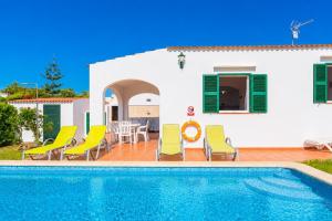 a villa with a swimming pool in front of a house at Villa Gelabert Ametller in Cala en Bosc
