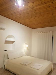 - une chambre avec un lit blanc et un plafond en bois dans l'établissement Peri Peri Holiday Home Catania, à Catane