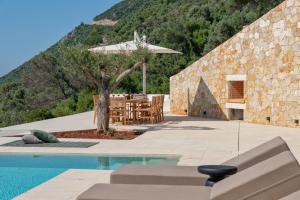 a villa with a swimming pool and a mountain at Deciel Cave Villa in Áyios Pétros