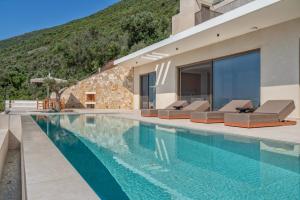 a house with a swimming pool next to a mountain at Deciel Cave Villa in Áyios Pétros