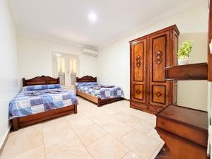 a bedroom with two beds and a dresser at Halla season matrouh in Marsa Matruh