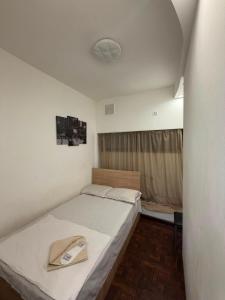 a small bedroom with a bed and a fan at D&A hotel in Yerevan