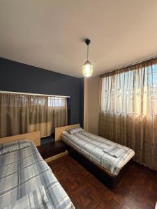 a bedroom with two beds and a window at D&A hotel in Yerevan