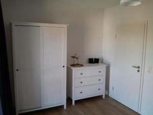 a bedroom with a white cabinet and a dresser at Das Rügenhaus in Lancken-Granitz