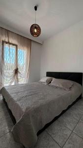 a bedroom with a bed and a large window at The Fernvills in Nea Kallikrateia