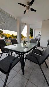 a dining room table with chairs and a ceiling fan at The Fernvills in Nea Kallikrateia