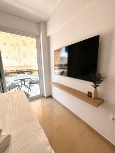 a bedroom with a large flat screen tv on a wall at Oli' Studio in Oropos