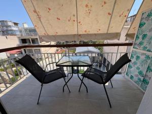 a table and two chairs on a balcony at Oli' Studio in Oropos