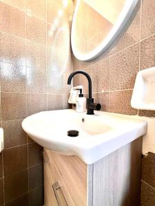 a bathroom with a white sink and a mirror at Oli' Studio in Oropos +3 photos