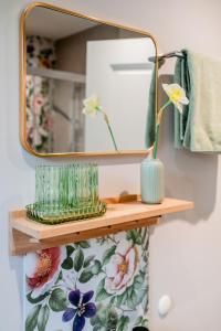 a mirror on a wall with vases on a shelf at Wild Wilderness in Schaalby +36 photos